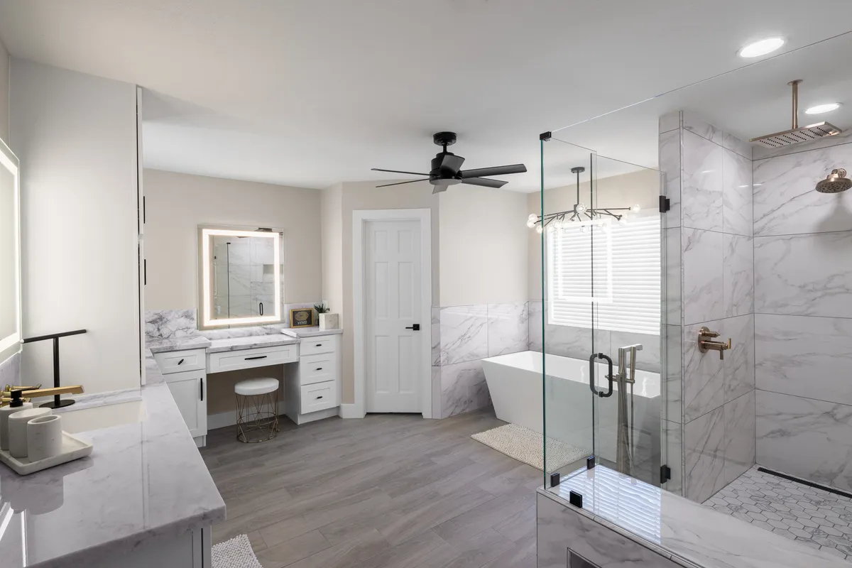 A tranquil bathroom scene with a freestanding soaking tub, a glass-enclosed walk-in shower, and a chic vanity area. The space exudes a spa-like feel, with neutral colors and soft lighting perfect for unwinding.
