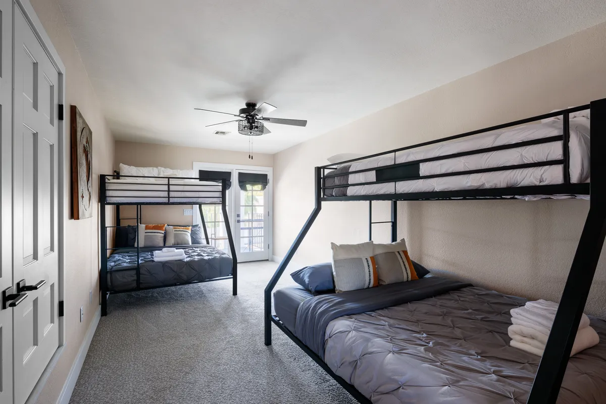 A playful, comfortable bedroom with bunk beds, textured bedding, and a window allowing in natural light. The space is ideal for families or groups, with a layout that encourages both privacy and togetherness.